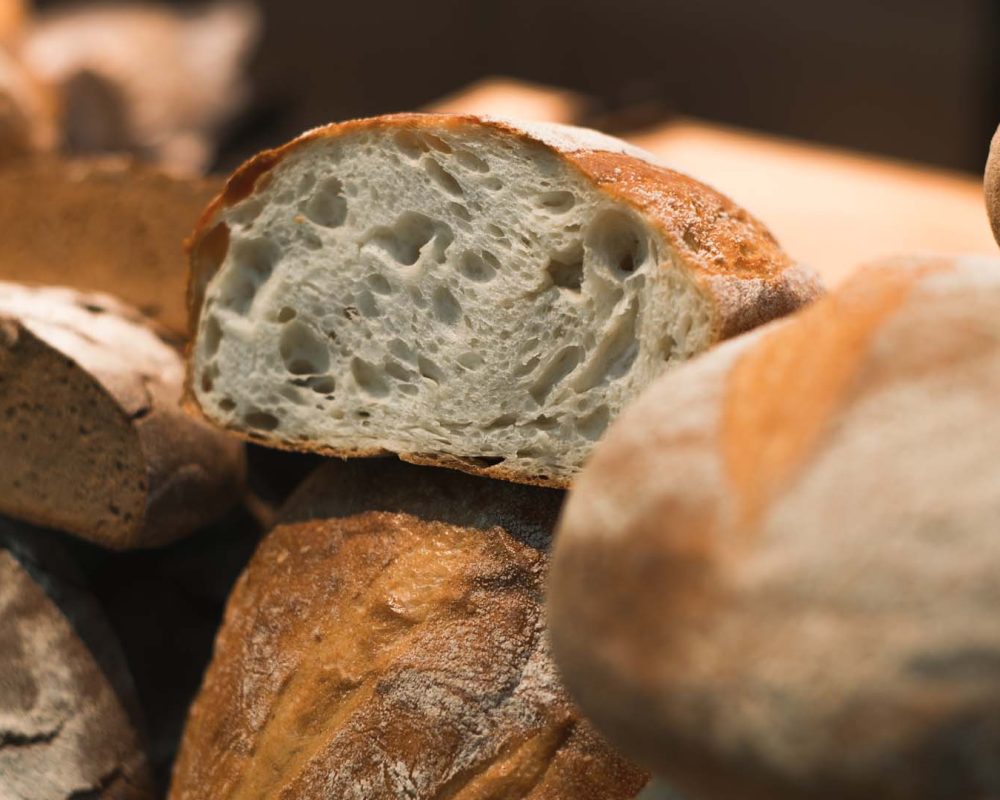 Baked fresh white and rye bread in shop window. Close-up, selective soft focus.